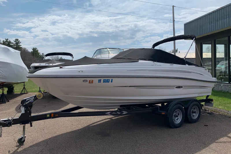 The Image of 2012 Sea Ray 200 Sundeck boat on trailer, covered and parked outdoors. - 0