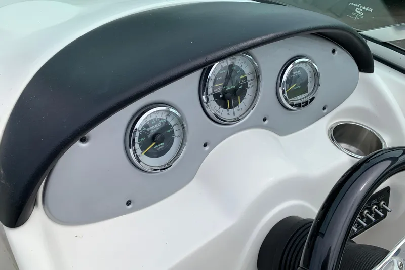 Slide: The Image of Dashboard of a 2012 Sea Ray 200 Sundeck boat with gauges and steering wheel. - 17