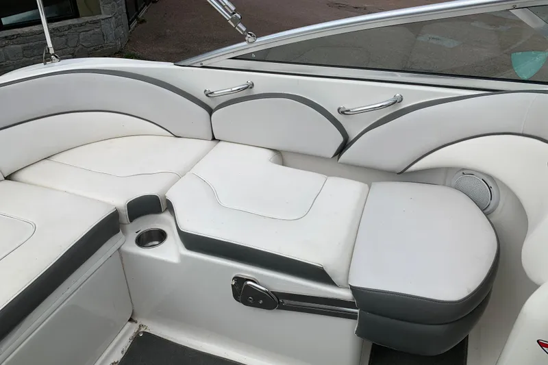 Slide: The Image of Interior seating of a 2012 Sea Ray 200 Sundeck boat, featuring white and gray upholstery. - 21