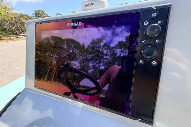 Slide: The Image of Simrad display on 2022 Chittum Skiffs Islamorada 21, reflecting trees and sky. - 27