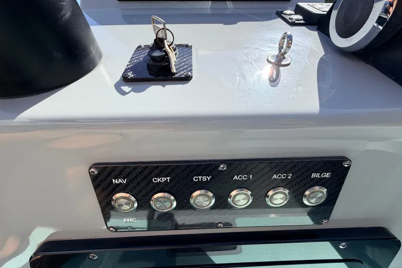 Slide: The Image of Control panel of 2022 Chittum Skiffs Islamorada 21 with labeled switches and key ignition. - 31