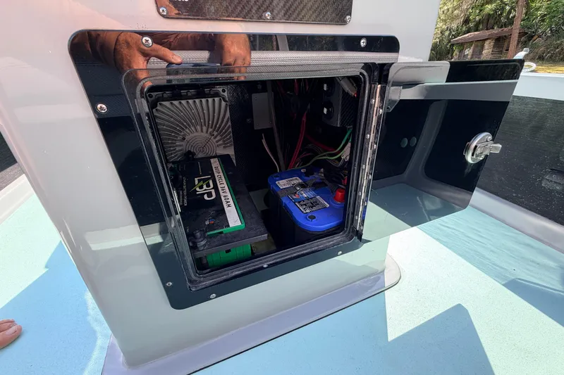 Slide: The Image of Open compartment of 2022 Chittum Skiffs Islamorada 21 showing battery and wiring. - 33