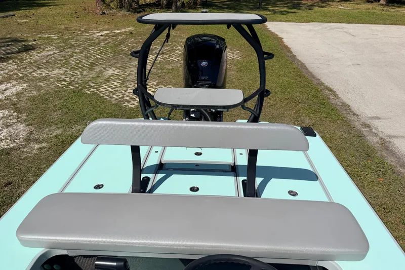 Slide: The Image of 2022 Chittum Skiffs Islamorada 21 boat with cushioned seating and motor, parked on grass. - 35