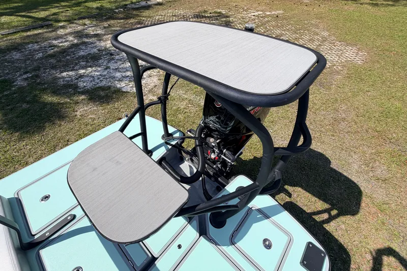 Slide: The Image of 2022 Chittum Skiffs Islamorada 21 boat with elevated platform and motor, on grassy terrain. - 57