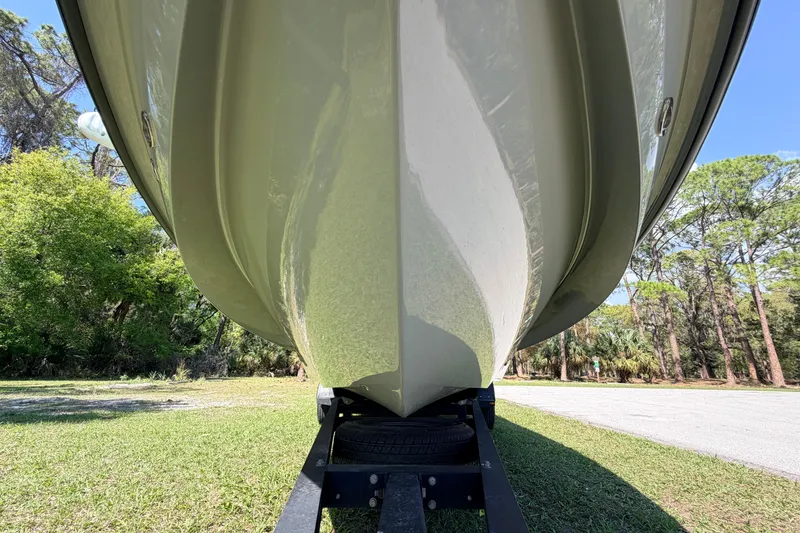 Slide: The Image of 2022 Chittum Skiffs Islamorada 21 boat hull on trailer, surrounded by trees. - 6