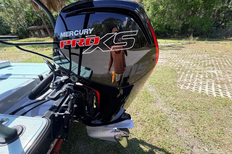Slide: The Image of 2022 Chittum Skiffs Islamorada 21 with Mercury Pro XS outboard motor in a grassy area. - 7