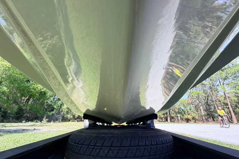 Slide: The Image of Underside view of 2022 Chittum Skiffs Islamorada 21 boat on trailer, surrounded by trees. - 70