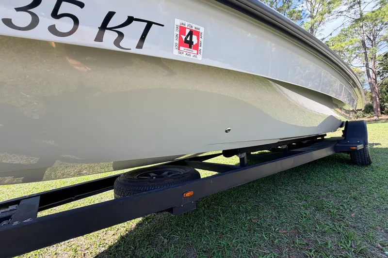 Slide: The Image of 2022 Chittum Skiffs Islamorada 21 on trailer, side view, grassy background. - 71
