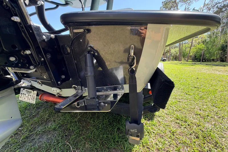 Slide: The Image of 2022 Chittum Skiffs Islamorada 21 boat transom with Texas license plate, parked on grass. - 77