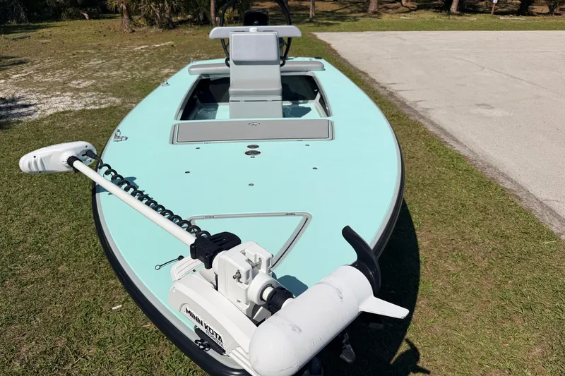 Slide: The Image of 2022 Chittum Skiffs Islamorada 21 boat with trolling motor on grassy area. - 8