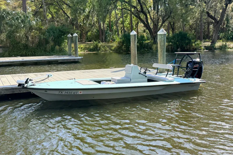 Slide: The Image of 2022 Chittum Skiffs Islamorada 21 boat docked on a serene river. - 89