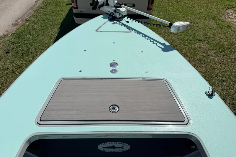 Slide: The Image of 2022 Chittum Skiffs Islamorada 21 boat deck with trolling motor, parked on grass. - 9