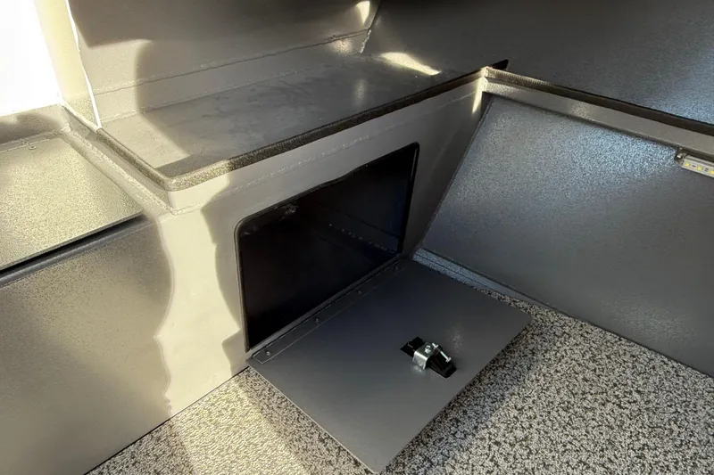 Slide: The Image of 2026 Alumaweld Stryker 202 boat storage compartment with open hatch and textured flooring. - 17