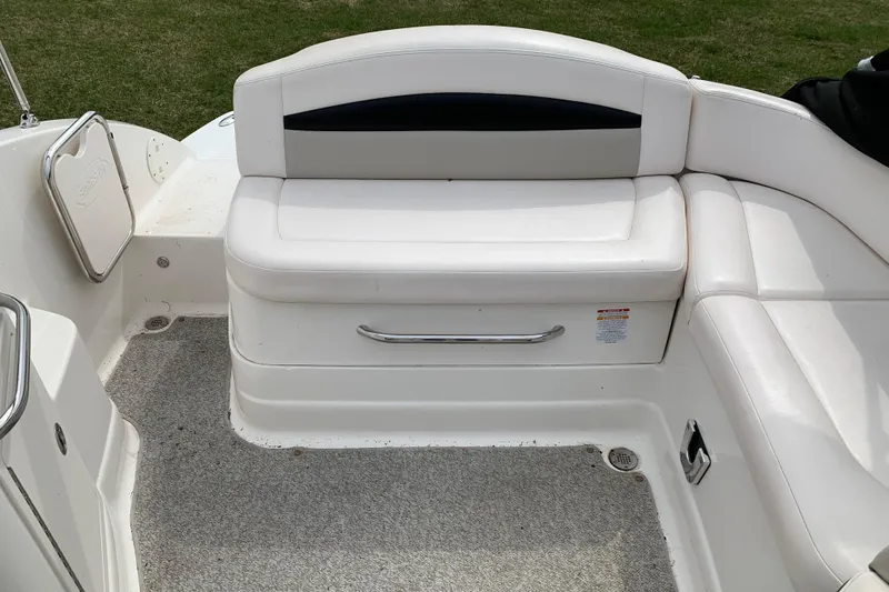Slide: The Image of 2008 Chaparral Sunesta 224 boat interior with white seating and storage compartment. - 18