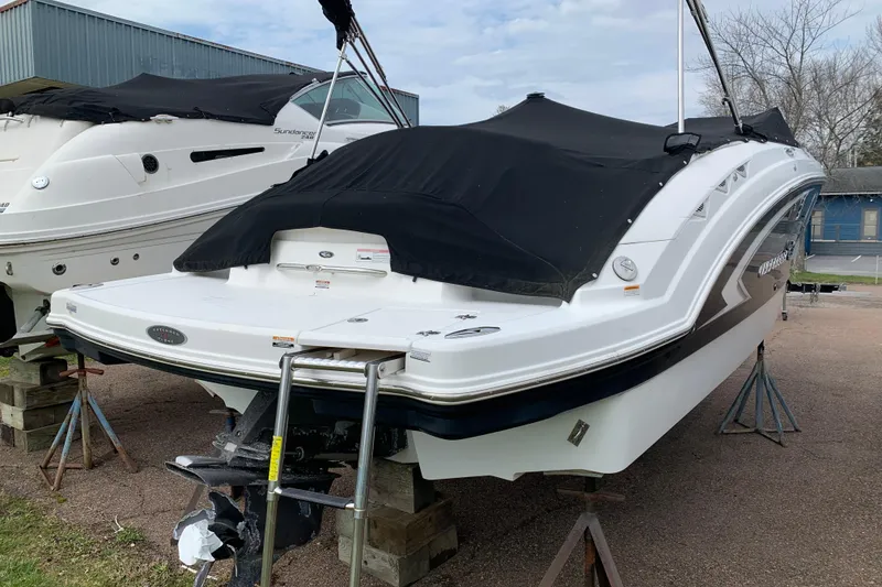 Slide: The Image of 2008 Chaparral Sunesta 224 boat with black cover, elevated on stands. - 8