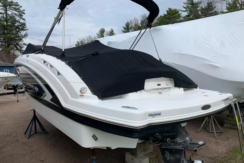 Slide: The Image of 2008 Chaparral Sunesta 224 boat with black cover, parked on a trailer outdoors. - 9