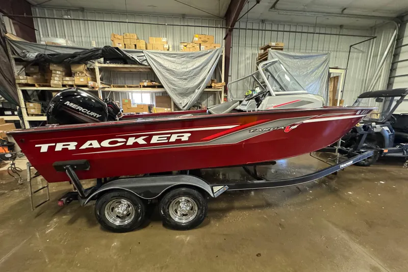 The Image of 2019 Tracker Targa V-18 WT boat in a warehouse, featuring a red exterior and Mercury engine. - 0