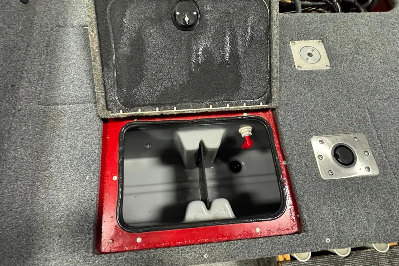 Slide: The Image of 2019 Tracker Targa V-18 WT boat storage compartment with open lid and visible interior. - 12