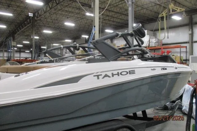 The Image of 2025 Tahoe 210 Si boat in warehouse, side view with visible branding. - 0