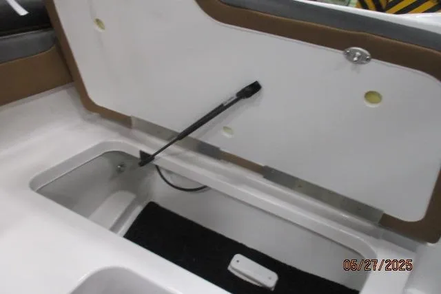 Slide: The Image of Open storage compartment in 2025 Tahoe 210 Si boat, featuring hydraulic lift support. - 10