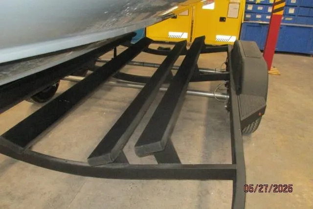 Slide: The Image of Boat trailer for 2025 Tahoe 210 Si, featuring padded supports in a garage setting. - 21