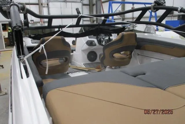 Slide: The Image of 2025 Tahoe 210 Si boat interior with tan and gray seating, steering wheel, and dashboard. - 5