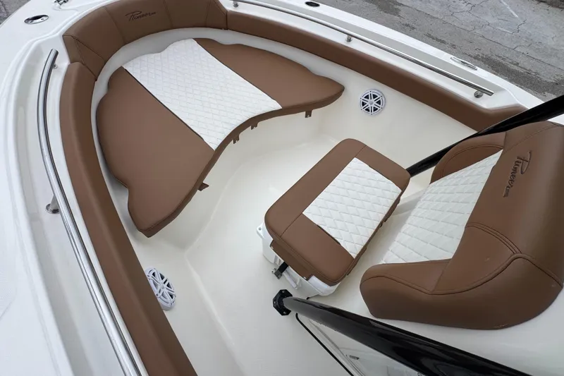 Slide: The Image of 2026 Pioneer 202 Sportfish boat interior with brown and white cushioned seating. - 11