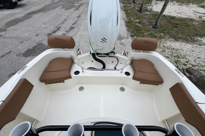 Slide: The Image of 2026 Pioneer 202 Sportfish boat interior with seating and motor, parked on pavement. - 5