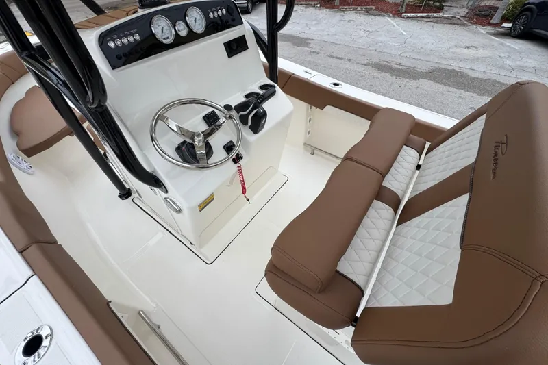 Slide: The Image of 2026 Pioneer 202 Sportfish boat interior with steering console and cushioned seating. - 8