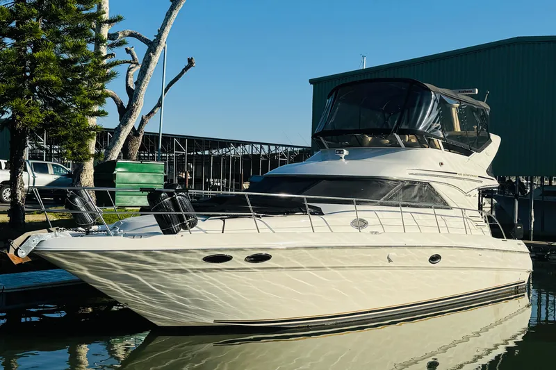 Slide: The Image of 2000 Sea Ray 400 Sedan Bridge yacht docked near trees and buildings. - 1