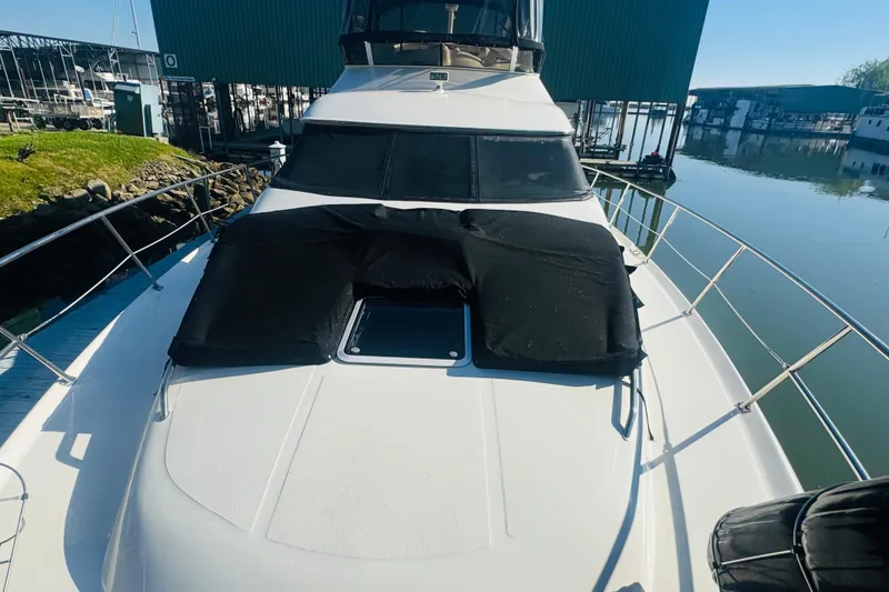Slide: The Image of 2000 Sea Ray 400 Sedan Bridge yacht docked at marina, featuring sleek design and sunpad. - 10
