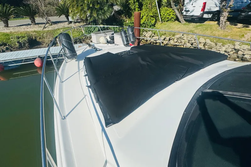 Slide: The Image of 2000 Sea Ray 400 Sedan Bridge yacht docked, featuring a covered deck area. - 11