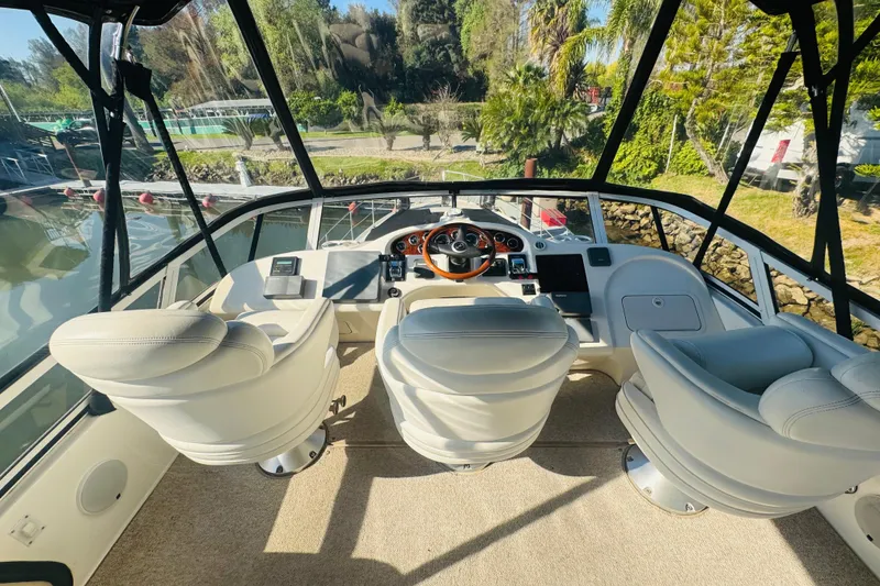 Slide: The Image of Cockpit of 2000 Sea Ray 400 Sedan Bridge with three white captain chairs. - 21