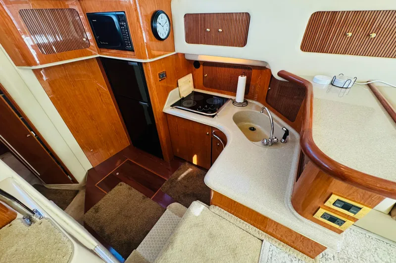 Slide: The Image of Interior of 2000 Sea Ray 400 Sedan Bridge yacht kitchen with wood cabinetry and modern appliances. - 36