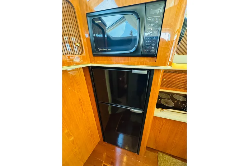 Slide: The Image of 2000 Sea Ray 400 Sedan Bridge kitchen with microwave and refrigerator. - 39