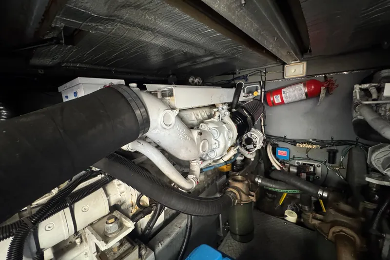 Slide: The Image of Engine room of a 2000 Sea Ray 400 Sedan Bridge with visible components and fire extinguisher. - 57