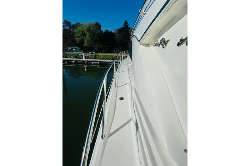 Slide: The Image of 2000 Sea Ray 400 Sedan Bridge yacht docked, showcasing sleek side view and railing. - 7
