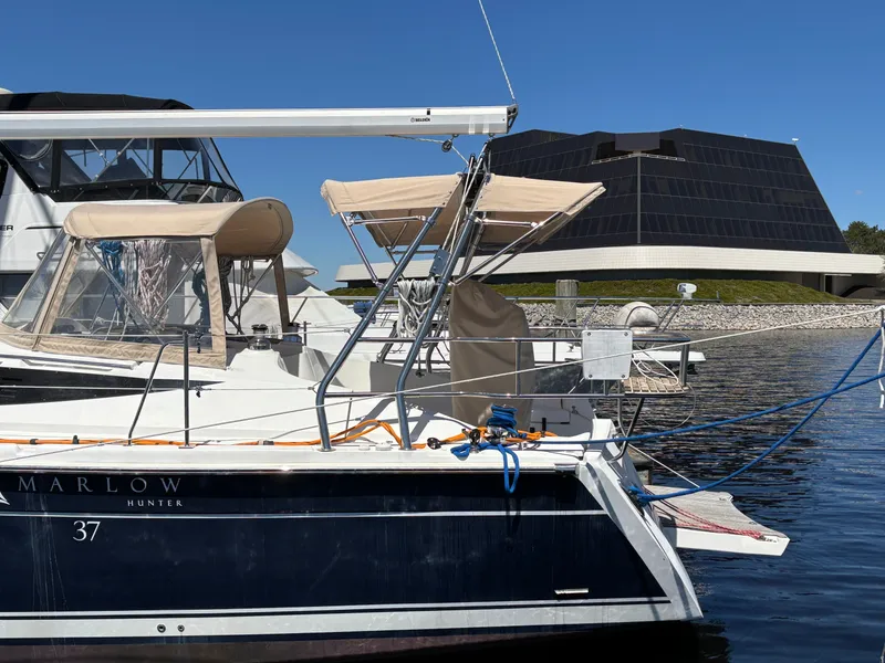 Slide: The Image of 2016 Marlow-Hunter 37 sailboat docked, modern building in background. - 5