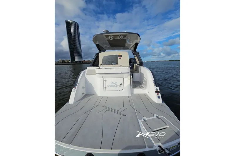 Slide: The Image of 2026 NX Boats NX310 on water, modern design, cityscape background. - 4