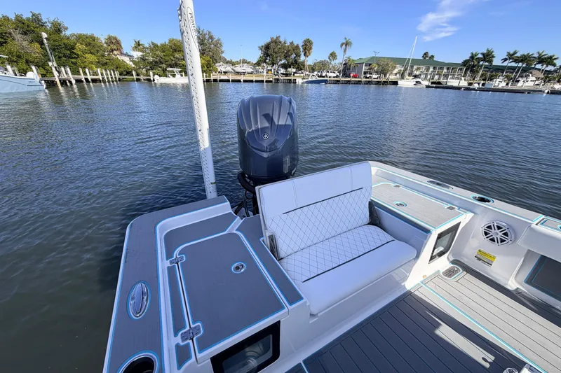 Slide: The Image of 2022 Sportsman Masters 247 Bay Boat docked, featuring seating and outboard motor. - 16