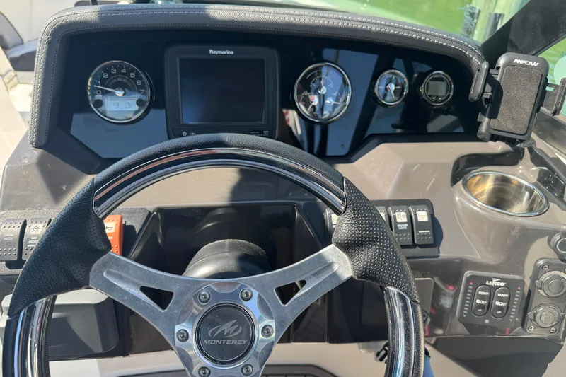 Slide: The Image of 2019 Monterey M-65 boat dashboard with steering wheel and control panel. - 24
