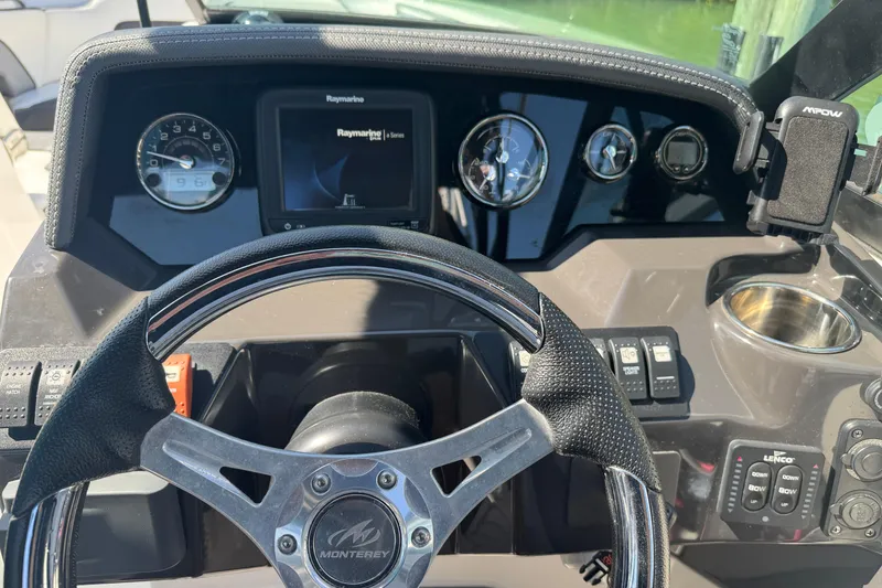Slide: The Image of Steering wheel and dashboard of a 2019 Monterey M-65 boat with navigation display. - 25