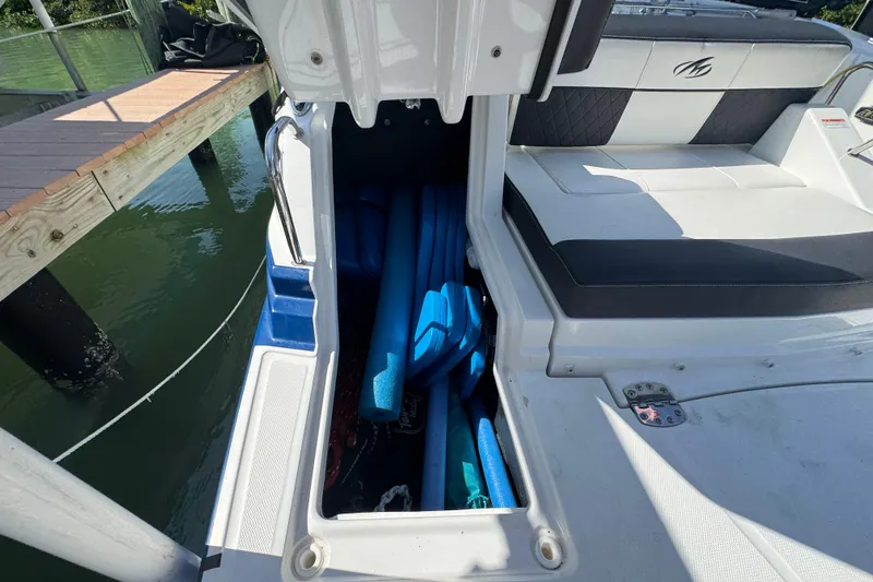 Slide: The Image of Storage compartment on a 2019 Monterey M-65 boat, containing blue pool noodles. - 30