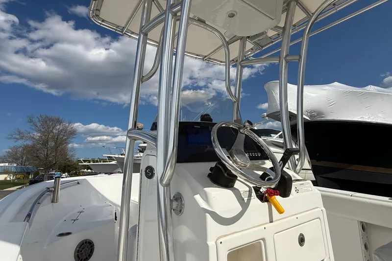 Slide: The Image of 2015 Sportsman Open 212 Center Console boat with steering wheel, under a blue sky. - 9