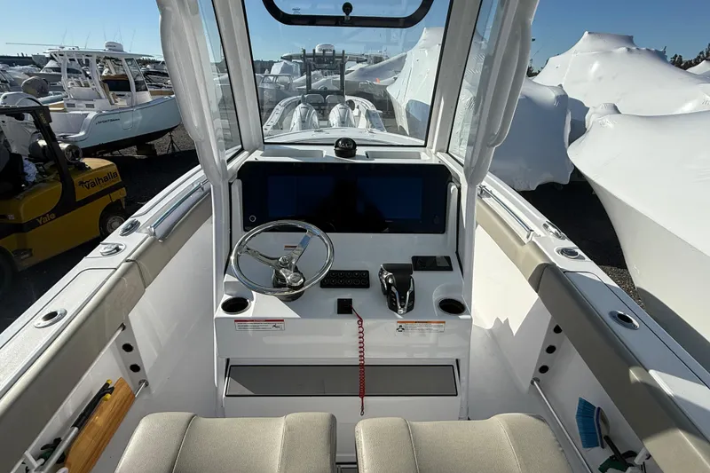 Slide: The Image of 2025 Sportsman Heritage 231 Center Console boat interior with steering wheel and controls. - 11