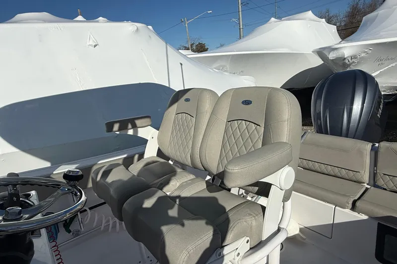 Slide: The Image of 2025 Sportsman Heritage 231 Center Console boat interior with cushioned seating and steering wheel. - 12