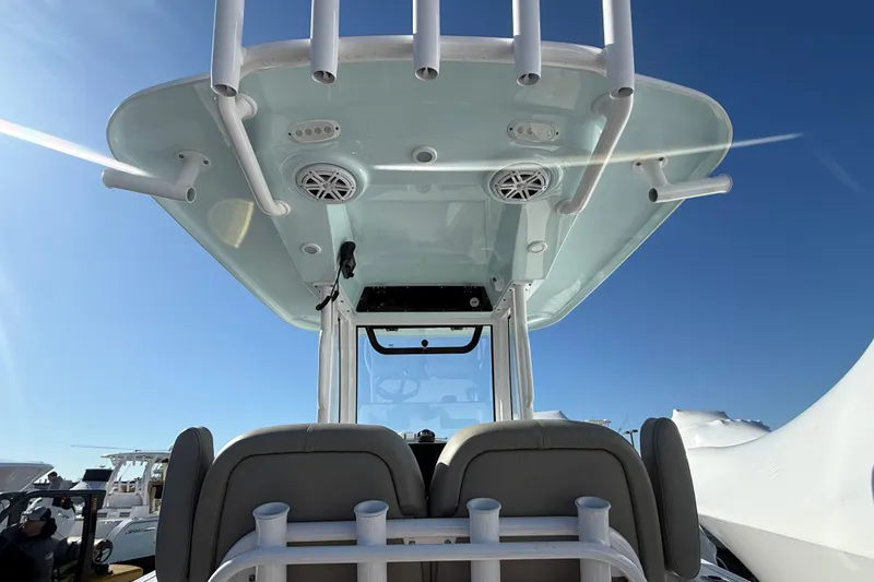Slide: The Image of 2025 Sportsman Heritage 231 Center Console boat interior with rod holders and speakers. - 13
