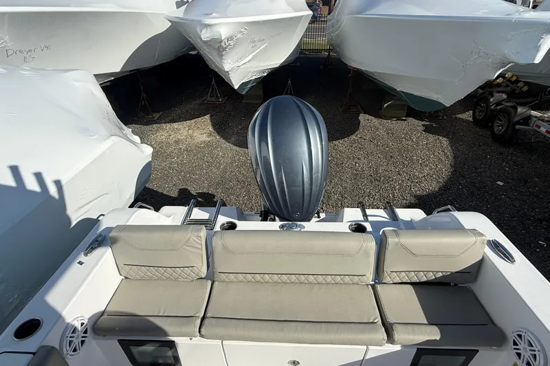 Slide: The Image of 2025 Sportsman Heritage 231 Center Console boat with cushioned seating and outboard motor. - 14