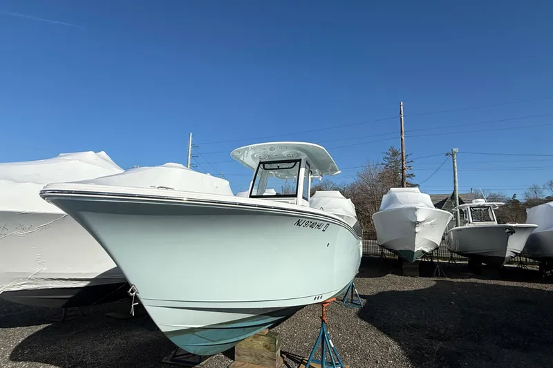 Slide: The Image of 2025 Sportsman Heritage 231 Center Console boat displayed outdoors under clear blue sky. - 2