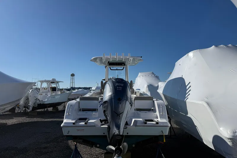 Slide: The Image of 2025 Sportsman Heritage 231 Center Console boat in storage, surrounded by covered vessels. - 4